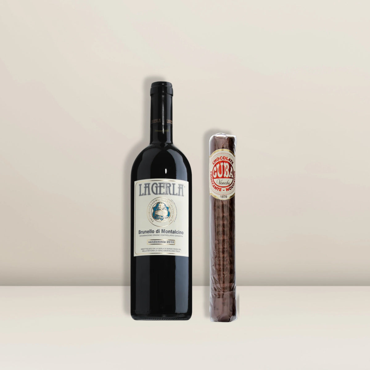 Eine Flasche Brunello di Montalcino DOCG 2018 steht neben einer verpackten Schokozigarre Truffle Nougatine-Schokoladentafel - präsentiert als „Pacster Gourmet Deluxe | Geschenkset“, die perfekte Wahl für den anspruchsvollen Gaumen.