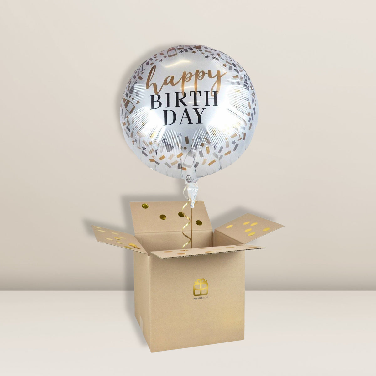 Ein metallischer „Happy Birthday Silver | Ballon“ von Pacster schwebt über einem offenen Karton, der mit goldenen Konfetti-Punkten gefüllt ist, vor einem schlichten beigen Hintergrund – der perfekte Geburtstagsgruß und das perfekte Geburtstagsgeschenk in einer einzigen bezaubernden Überraschung. Entdecke hochwertige Ballons bei Pacster.