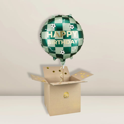 Ein grün-weißer Pacster-Fußball mit der Aufschrift „Happy Birthday“ | Der Ballon schwebt über einem offenen Karton, der mit goldenen Punkten und einem Geschenksymbol verziert ist – das perfekte Geburtstagsgeschenk. Dieser festliche Heliumballon kommt vor einem schlichten, hellen Hintergrund besonders gut zur Geltung. Entdecke hochwertige Ballons bei Pacster.