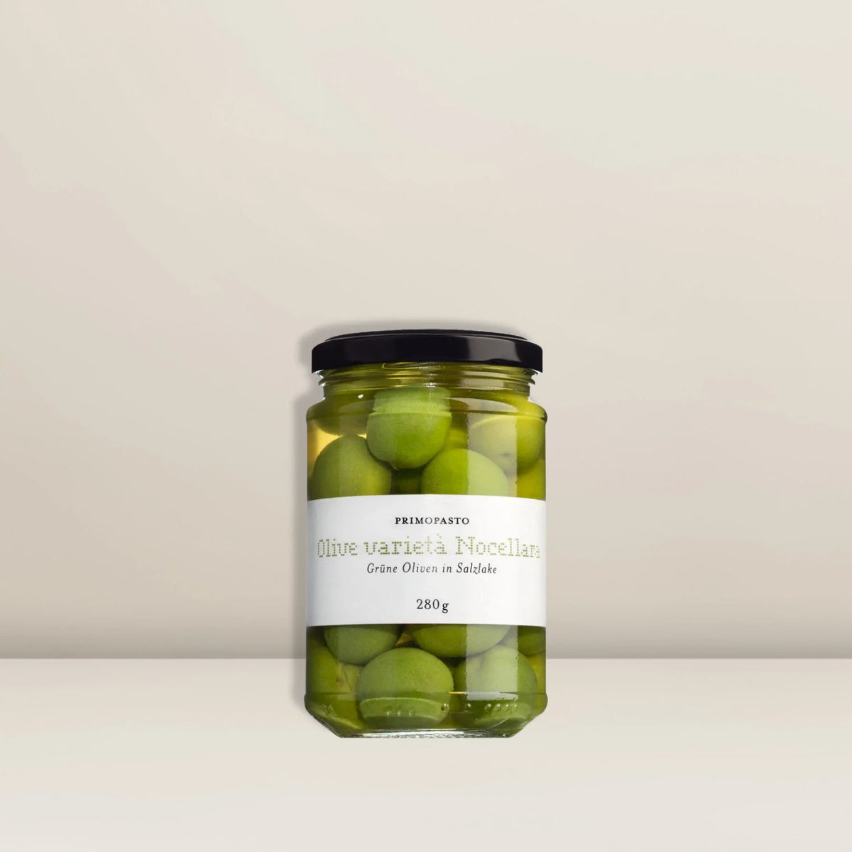 Ein Glas mit „Viani Oliven Grün“, gefüllt mit ganzen grünen Nocellara-Oliven in Salzlake, mit der Aufschrift „Olive varietà Nocellara“ und einem Gewicht von 280 g, mit schwarzem Deckel vor einem schlichten, hellen Hintergrund. Diese sizilianischen Oliven gelten als die perfekten Tafeloliven für jeden Anlass. Entdecke hochwertige Geschenke bei Pacster.
