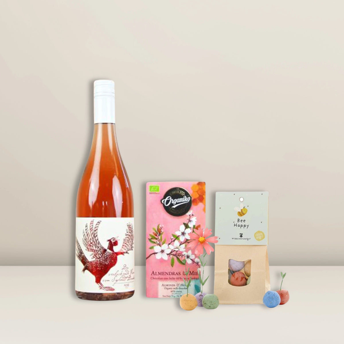 Das „Sommerlicher Genuss | Geschenkset“ von Pacster enthält eine Flasche Roséwein, Vollmilchschokolade mit Mandeln und Honig, eine kleine Tüte mit bunten Samenkugeln sowie eine Grußkarte – alles wunderschön in einer Magnetbox arrangiert und auf einem hellen Untergrund vor einem schlichten Hintergrund präsentiert. Entdecke hochwertige Geschenkideen bei Pacster.