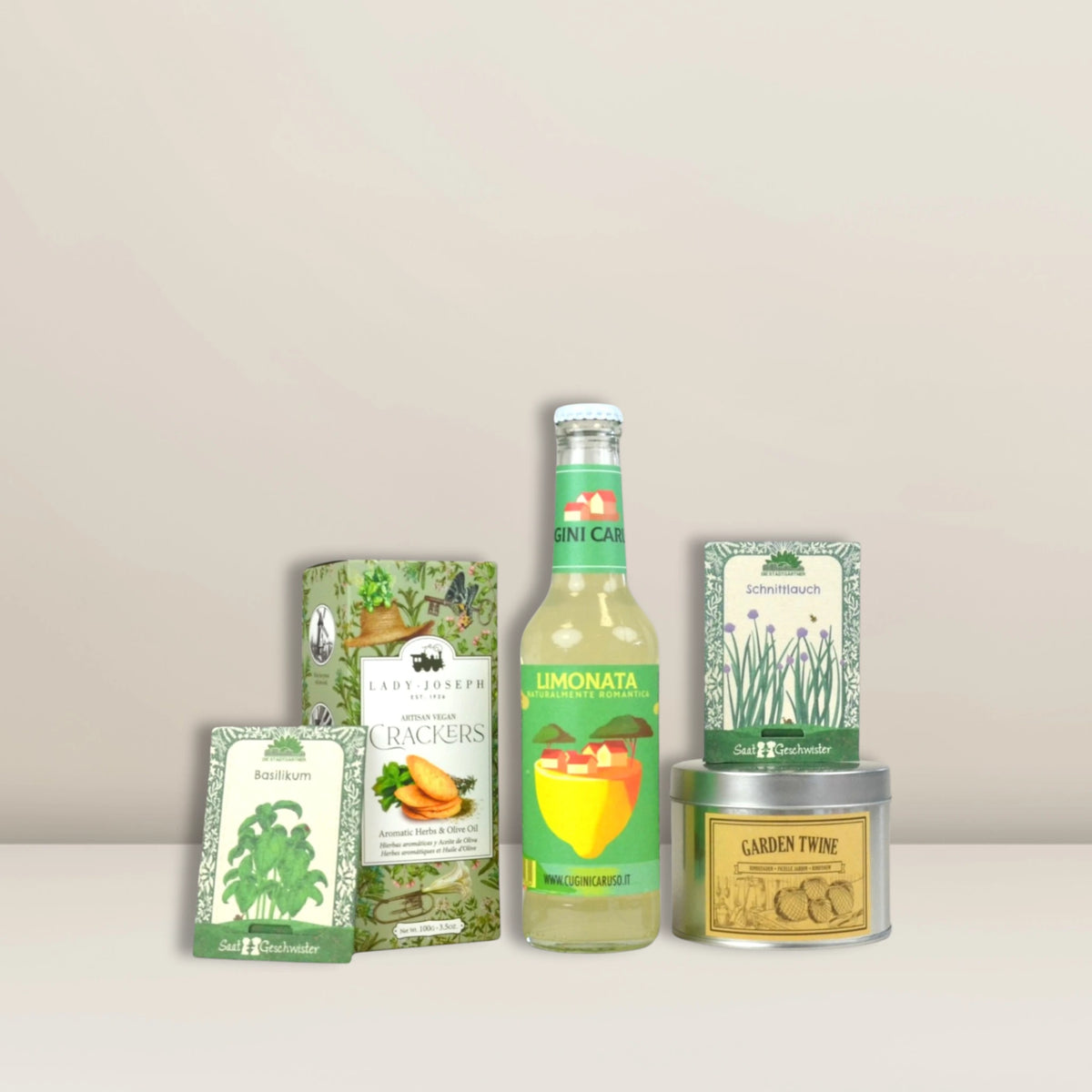 Das „Kleiner Kräutergarten | Geschenkset“ von Pacster – eine Auswahl an grün und gelb verpackten Lebensmitteln wie Cracker, ein Zitronengetränk, Tee und Kräuter –, ist das perfekte Geschenk für Genussmenschen.